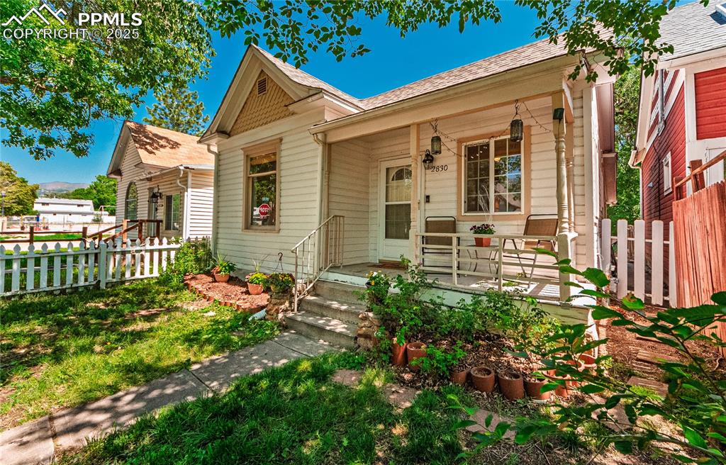 Image 7 of 36: View of front facade with covered porch and a shingled roof