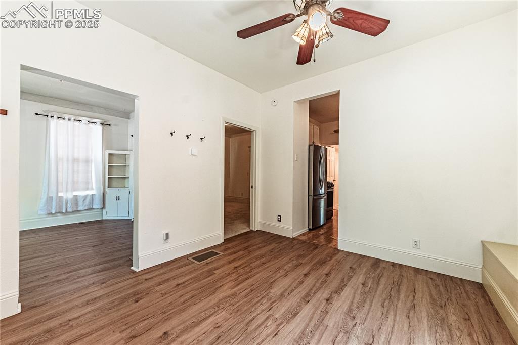 Image 8 of 36: Empty room with ceiling fan and wood finished floors