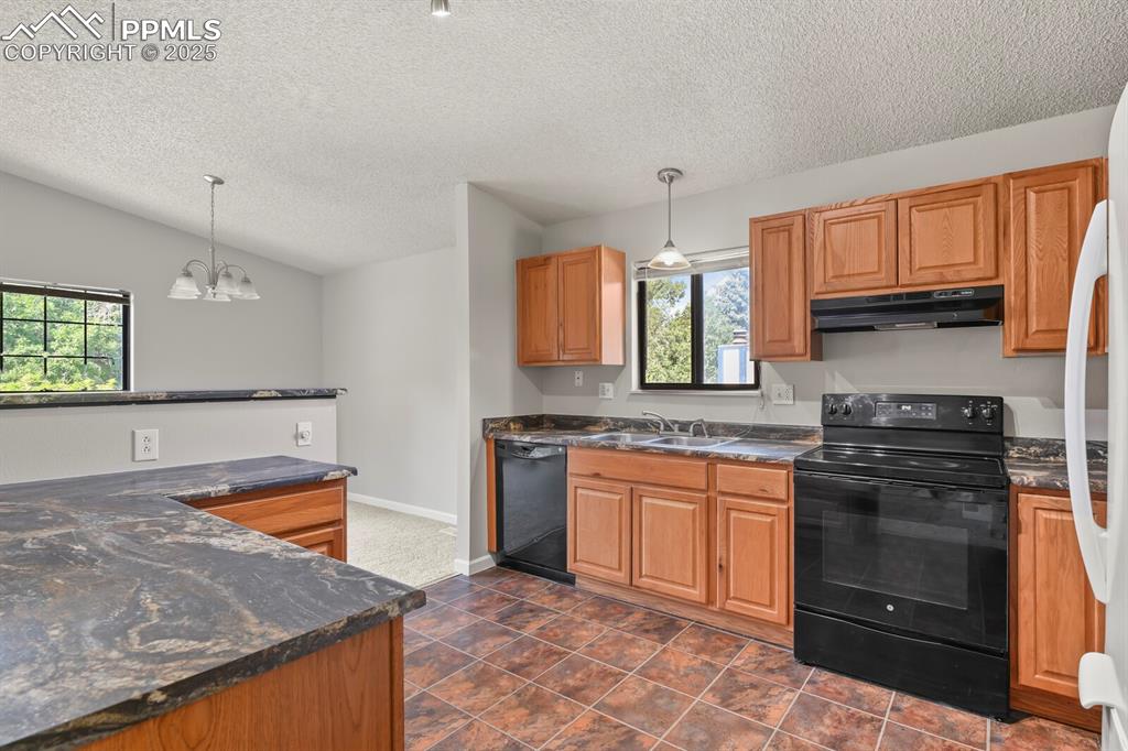 Image 13 of 39: Kitchen featuring black appliances, dark countertops, a textured ceiling, u