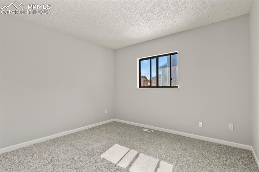Image 20 of 39: Carpeted spare room featuring a textured ceiling and baseboards
