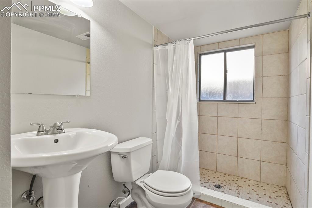 Image 28 of 39: Full bath featuring toilet and a tile shower