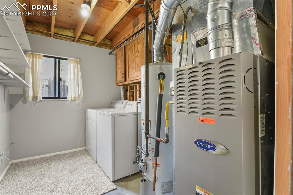 Image 32 of 39: Laundry room featuring separate washer and dryer, heating unit, gas water h