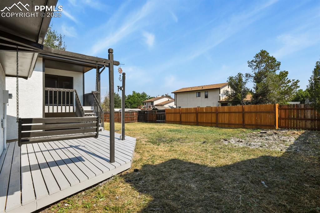 Image 35 of 39: Fenced backyard featuring a wooden deck