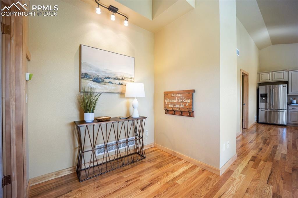 Image 13 of 50: Corridor with light wood finished floors and lofted ceiling