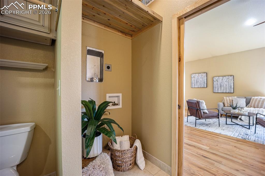 Image 25 of 50: Corridor with light wood-style floors and a textured wall