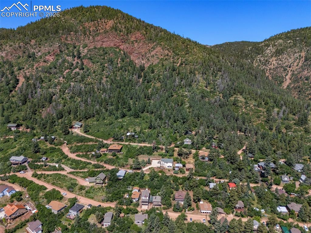 Image 3 of 50: Drone / aerial view of a mountain backdrop and a heavily wooded area