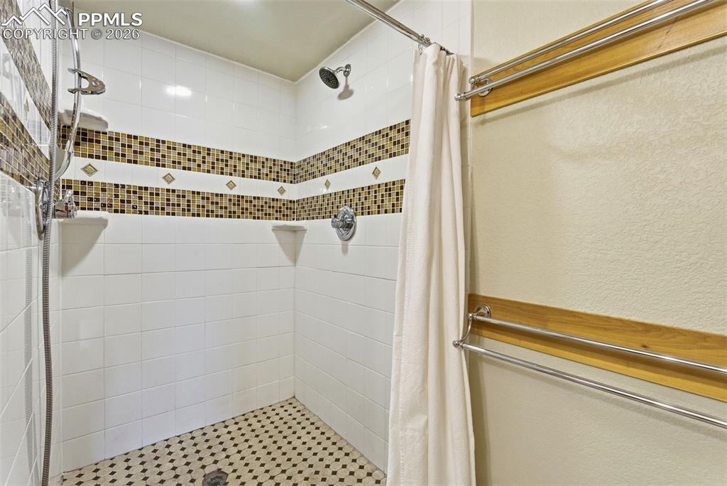 Image 33 of 50: Full bath with a stall shower and a textured wall