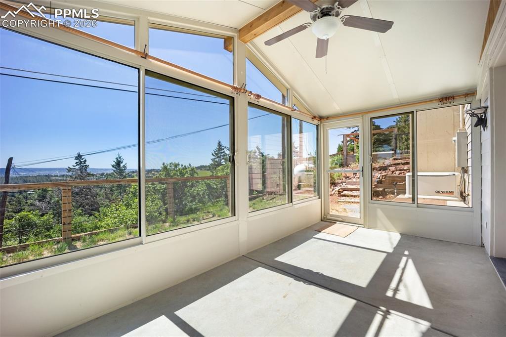 Image 36 of 50: Unfurnished sunroom featuring a ceiling fan and beamed ceiling