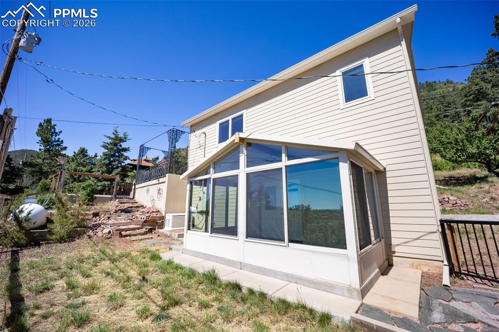 Image 38 of 50: Back of property featuring a sunroom and a patio area