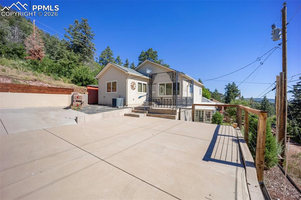 Image 4 of 50: View of front facade featuring a patio and a wooden deck