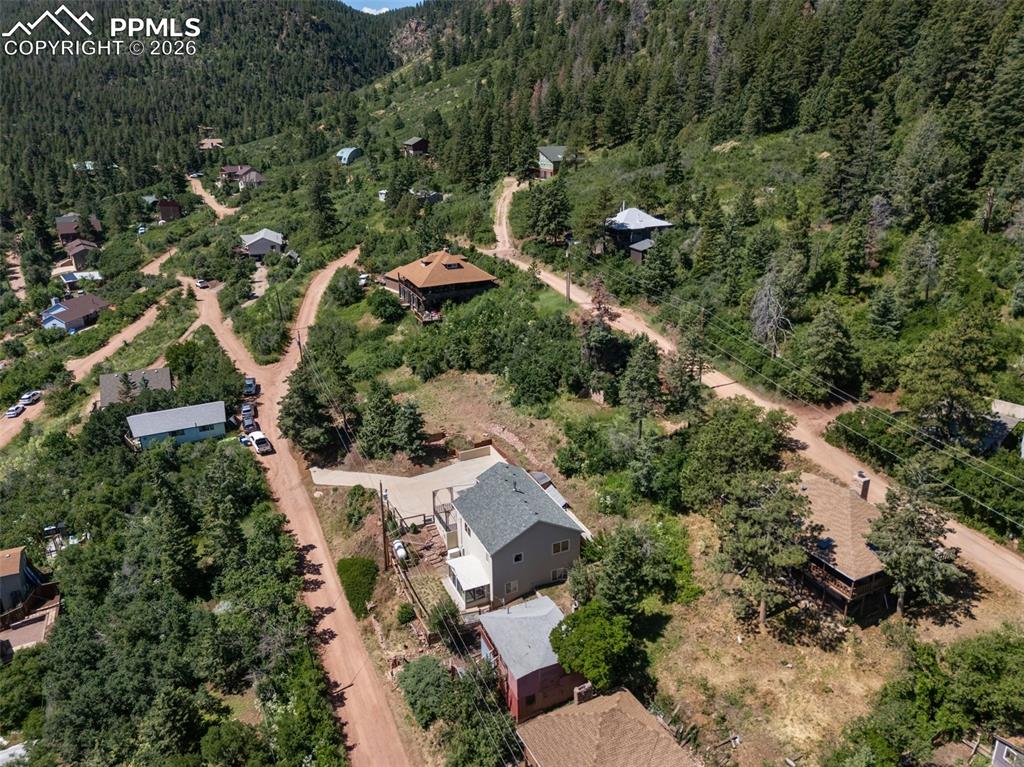 Image 44 of 50: Aerial view of property and surrounding area featuring a forest