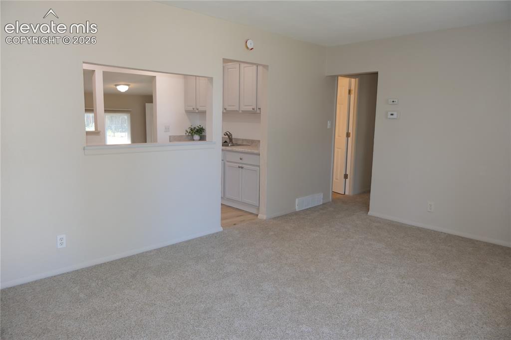 Image 2 of 39: Living room looking towards kitchen & hallway from entry