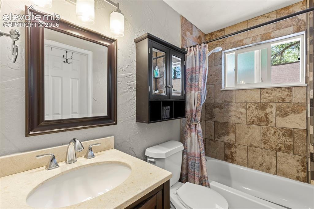 Image 17 of 30: upper Bathroom. vanity with an oval undermount sink, chrome faucet, and lig