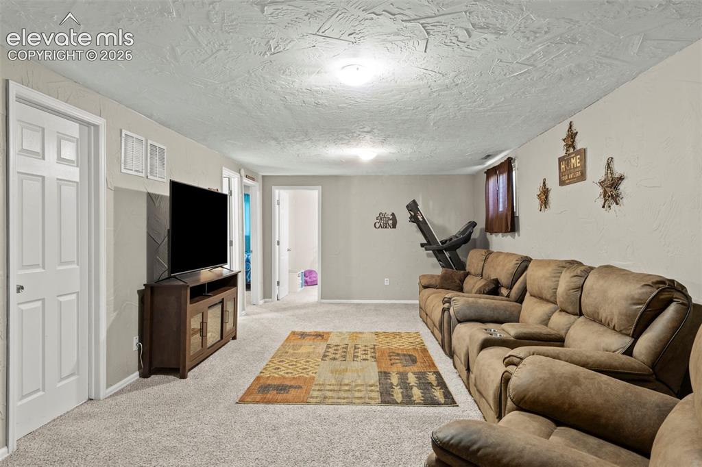 Image 19 of 30: Spacious room featuring light gray carpeting, neutral wall colors, recessed