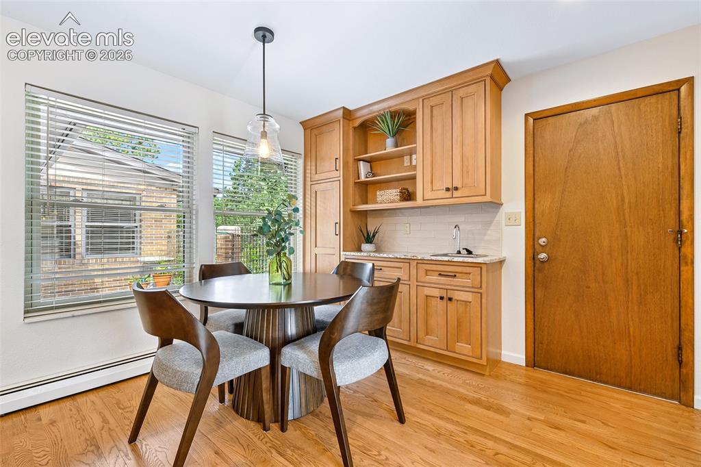 Image 13 of 49: Dining area in kitchen overlooks front courtyard