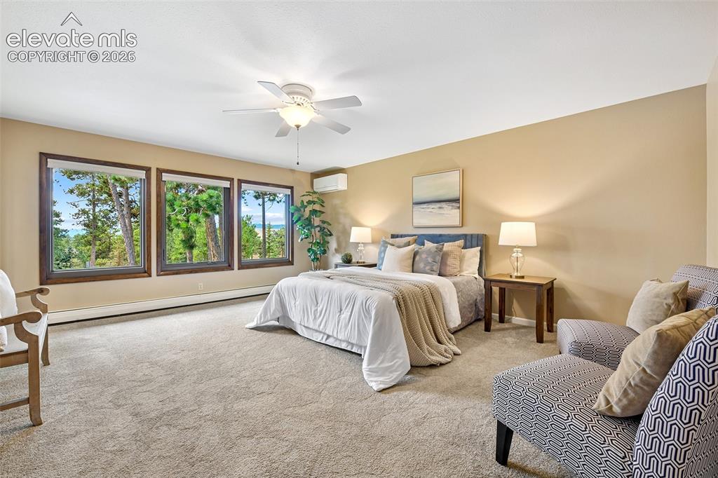 Image 17 of 49: Mountain Views abound through the forested views from the spacious primary 