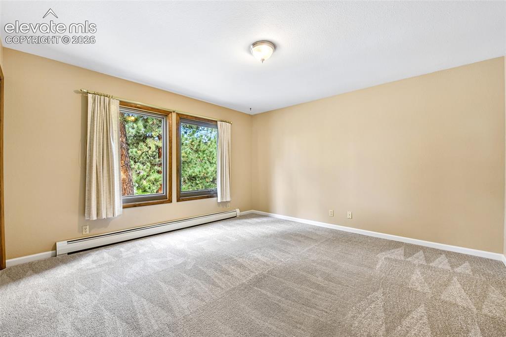 Image 24 of 49: Third bedroom with wooded views