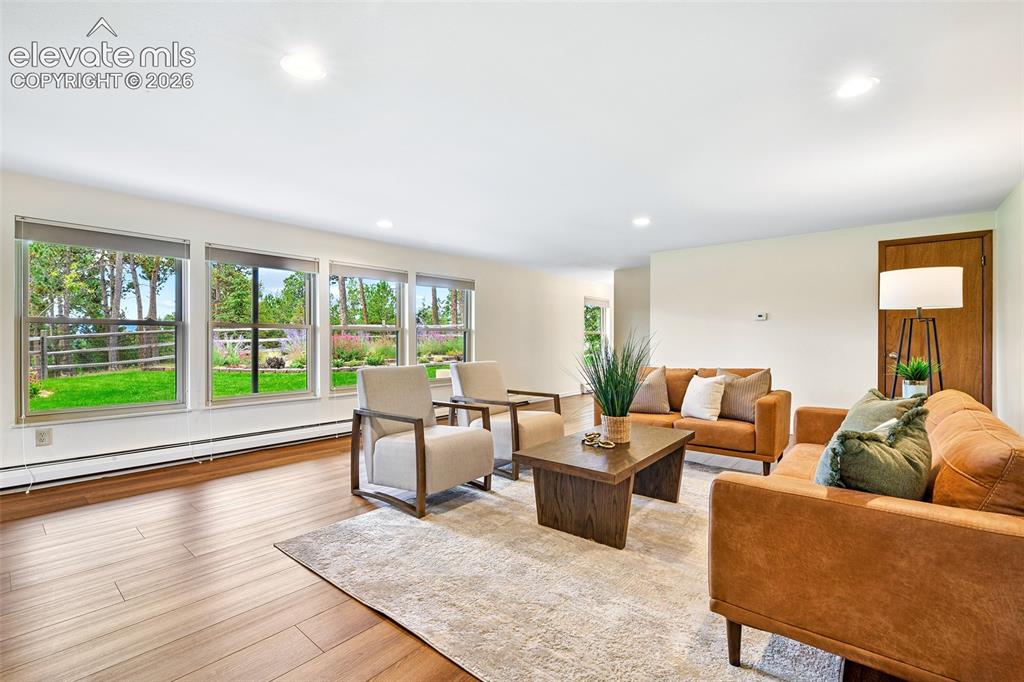 Image 26 of 49: Enormous, lower level family room has LVP flooring and views of gardens as 
