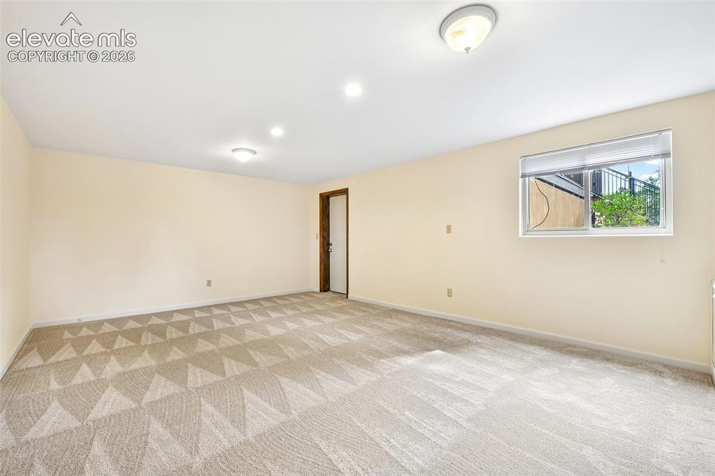Image 38 of 49: Fifth bedroom with window overlooking tiered gardens and cold storage/safe