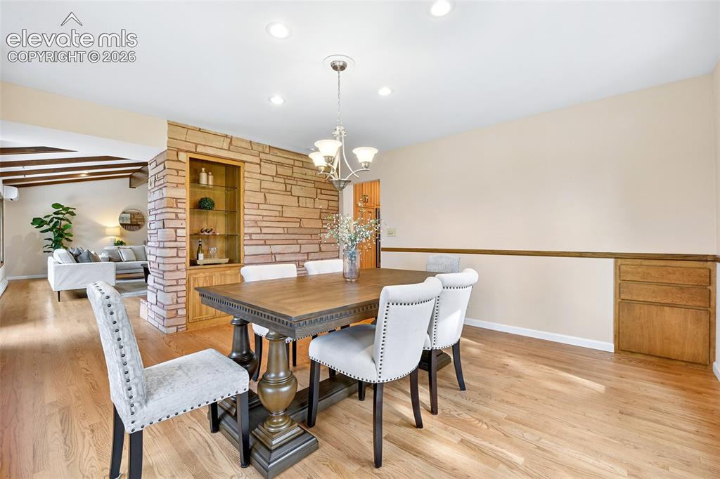 Image 6 of 49: Formal Dining Room with built-ins, hardwood flooring and kitchen access.