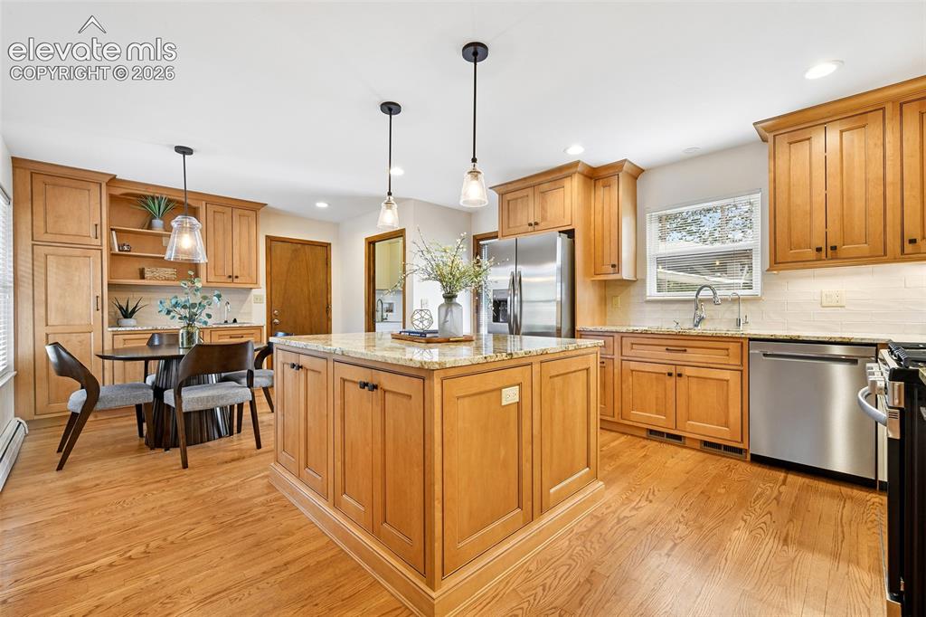 Image 9 of 49: Expansive eating kitchen with hardwoods and gorgeous maple cabinetry.