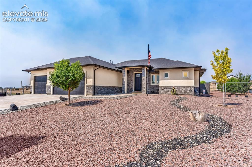 Image 1 of 49: Contemporary single-story residence with a two-car garage, stone and stucco