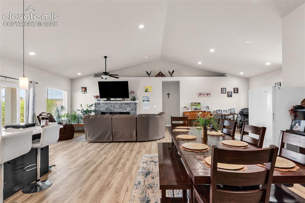Image 14 of 49: Open-concept living space with vaulted ceilings and wood-finish flooring
