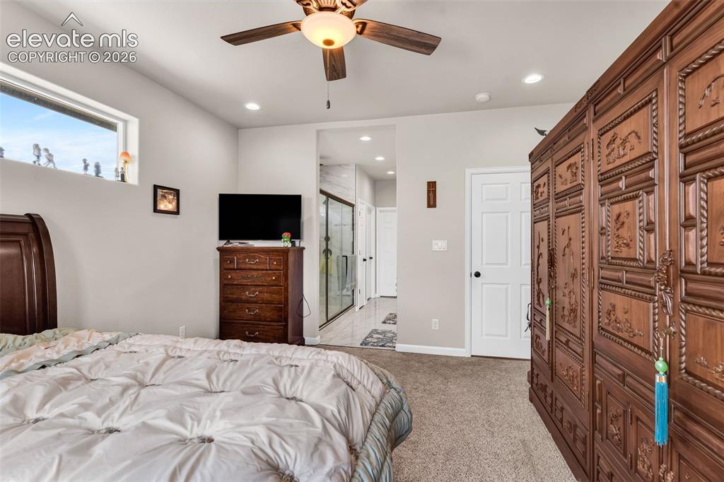 Image 19 of 49: Carpeted bedroom featuring a ceiling fan with light, recessed lighting, and