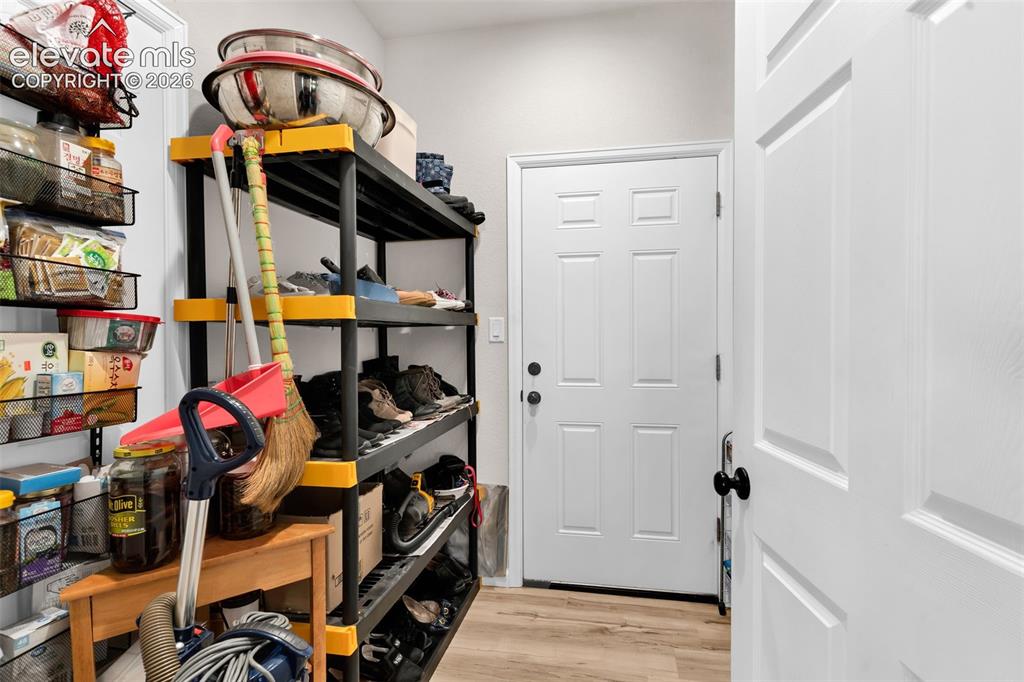 Image 27 of 49: Utility room featuring light wood-finish flooring, white walls, and a panel