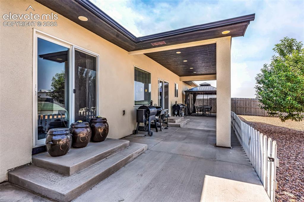 Image 30 of 49: Spacious concrete patio with a covered outdoor living area