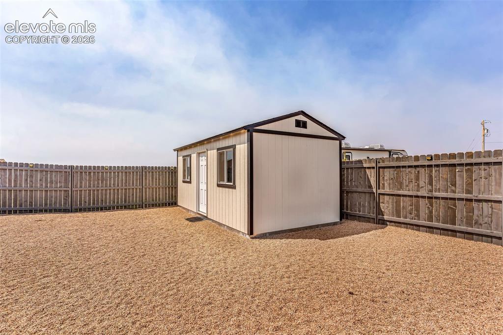 Image 38 of 49: Dedicated storage shed featuring a single door, two windows, and a pitched