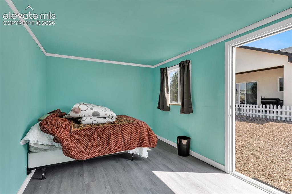Image 39 of 49: Interior space featuring wood-finish flooring, two windows with dark curtai