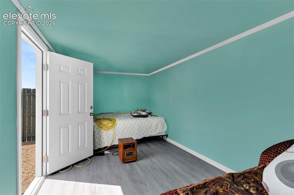 Image 40 of 49: Interior space featuring vibrant blue-green walls, white trim, and wood-fin