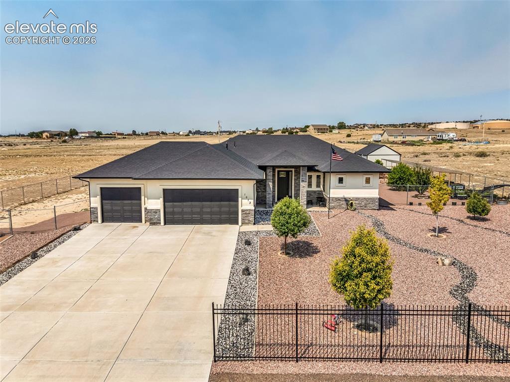 Image 46 of 49: Contemporary residence featuring a dark shingle roof and a light-toned exte