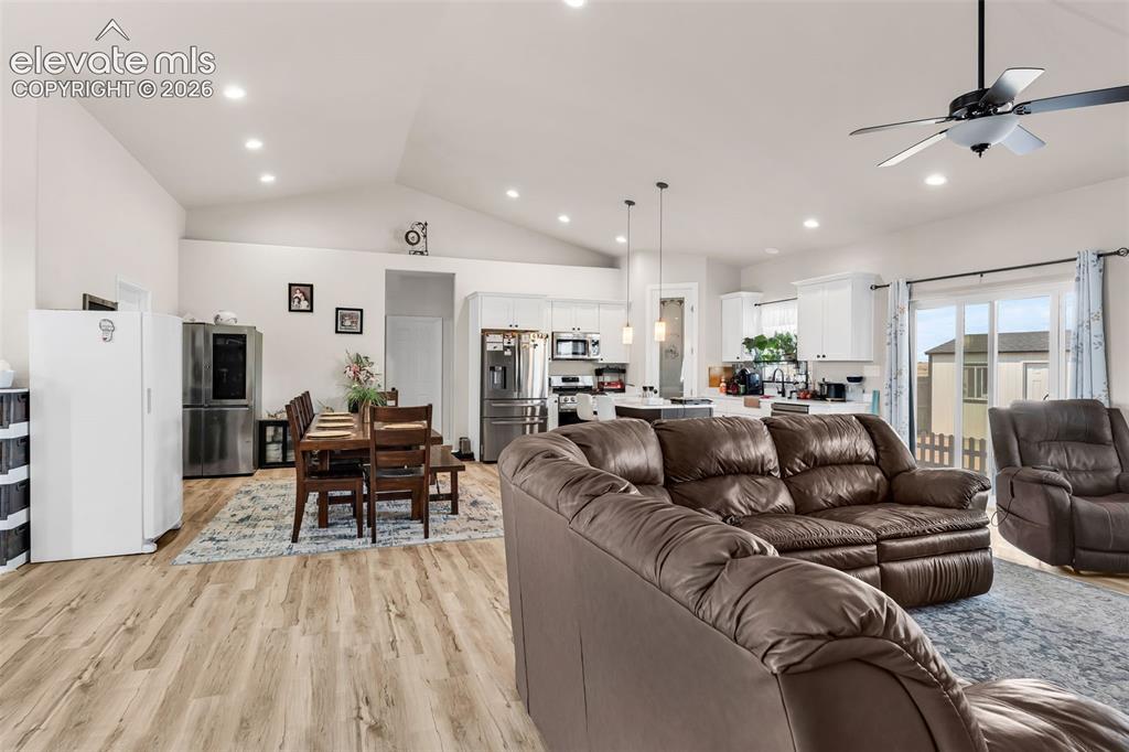 Image 9 of 49: Open-concept living area featuring vaulted ceilings with recessed lighting,