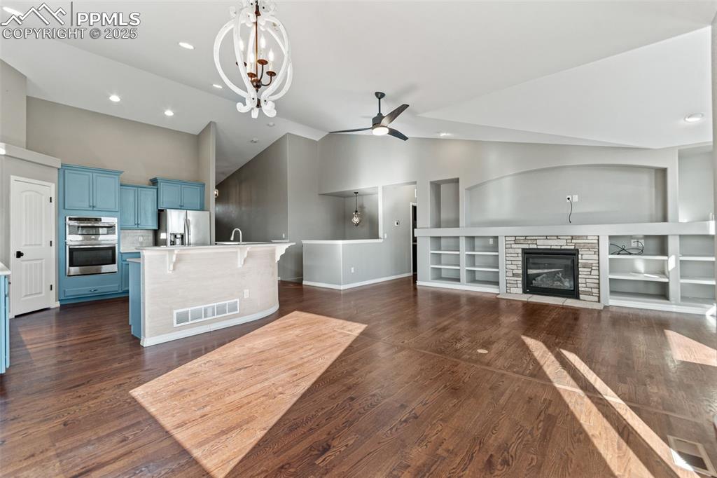 Image 12 of 45: Living room featuring a stone fireplace, recessed lighting, dark wood-style