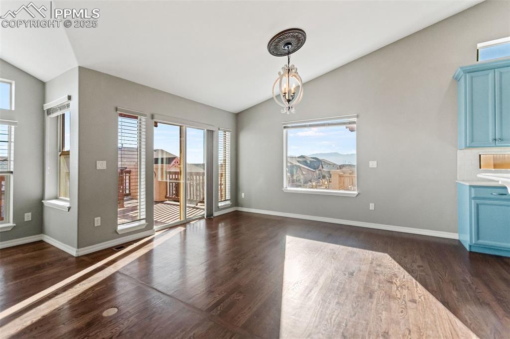 Image 15 of 45: Dining area with lofted ceiling, dark wood-style flooring, and a chandelier