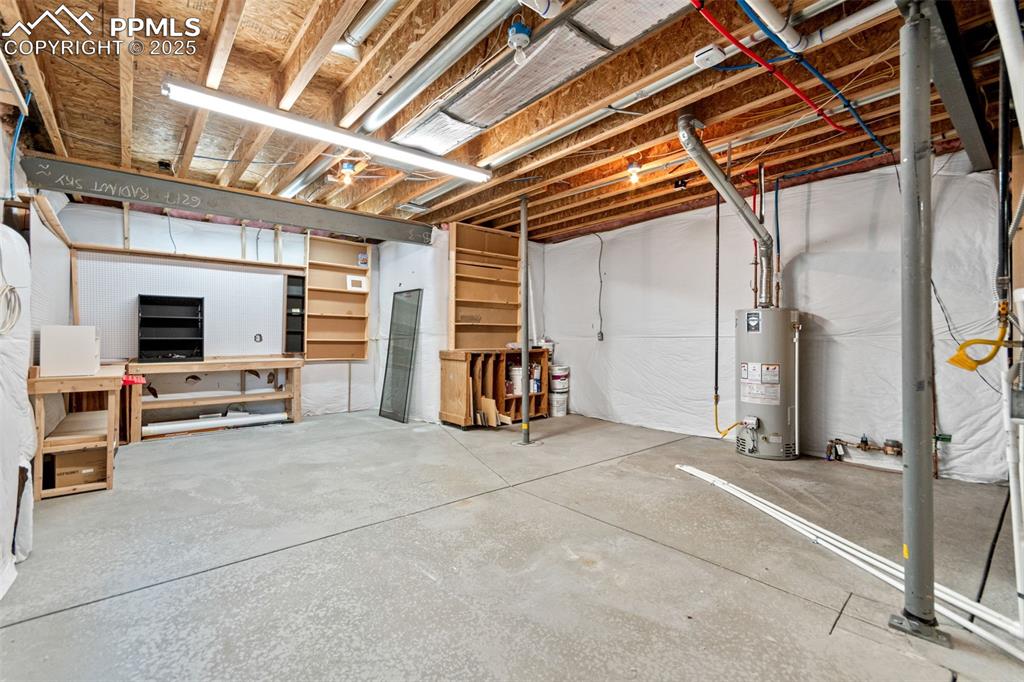 Image 40 of 45: Unfinished basement space perfect for storage, gym, or shop.