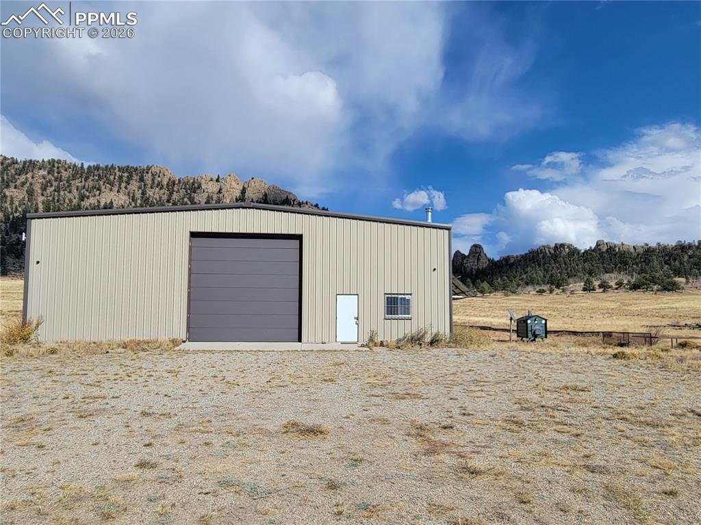 Image 1 of 43: The property features a 60x60 metal building with a roll-up garage door and