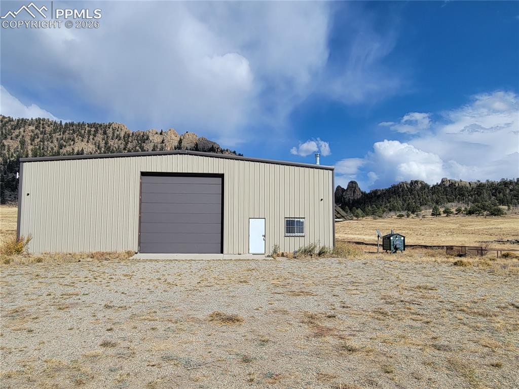 Image 1 of 42: The property features a 60x60 metal building with a roll-up garage door and