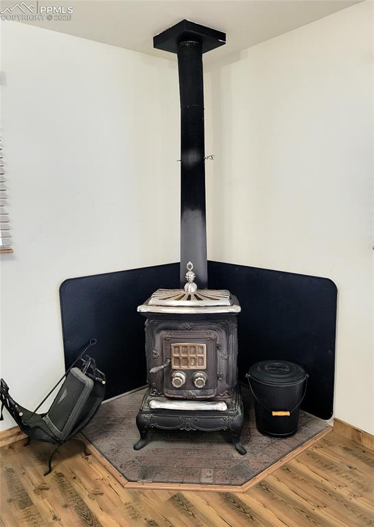 Image 10 of 42: The living area features a corner wood-burning stove