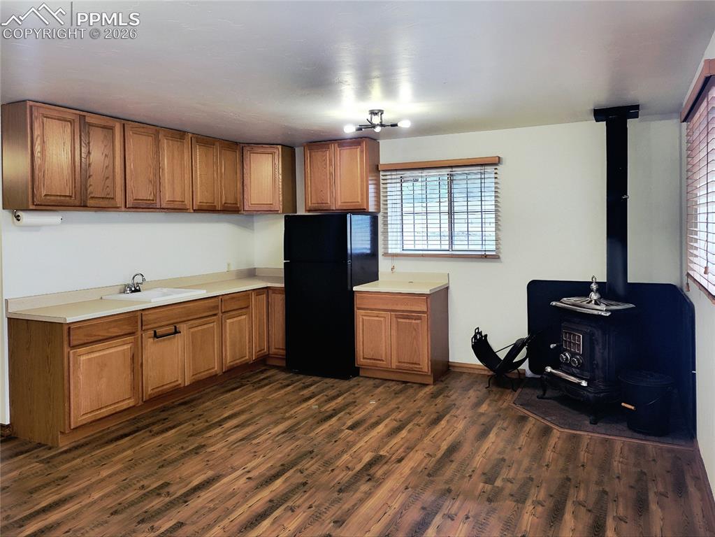 Image 11 of 42: This versatile space features wood-look flooring, light wood cabinetry, and