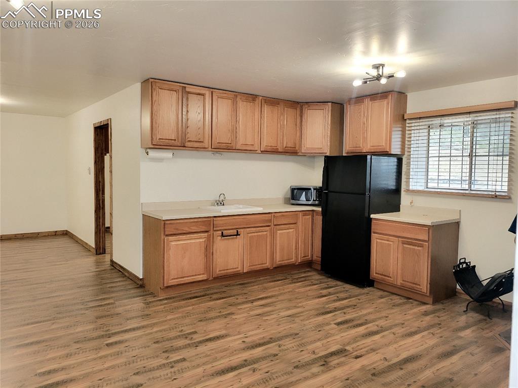 Image 12 of 43: Kitchen area featuring wood-look flooring, light wood cabinetry, a sink wit