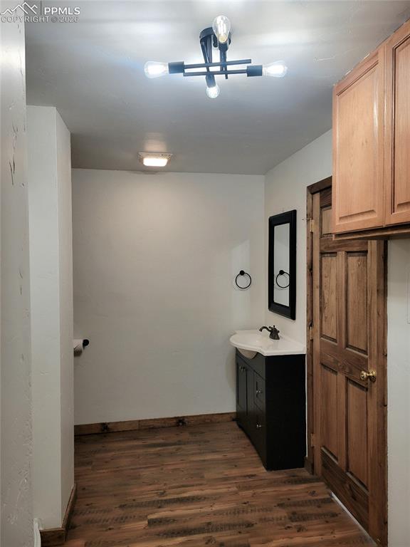 Image 16 of 42: The property features wood-style flooring, a dark vanity with a white count