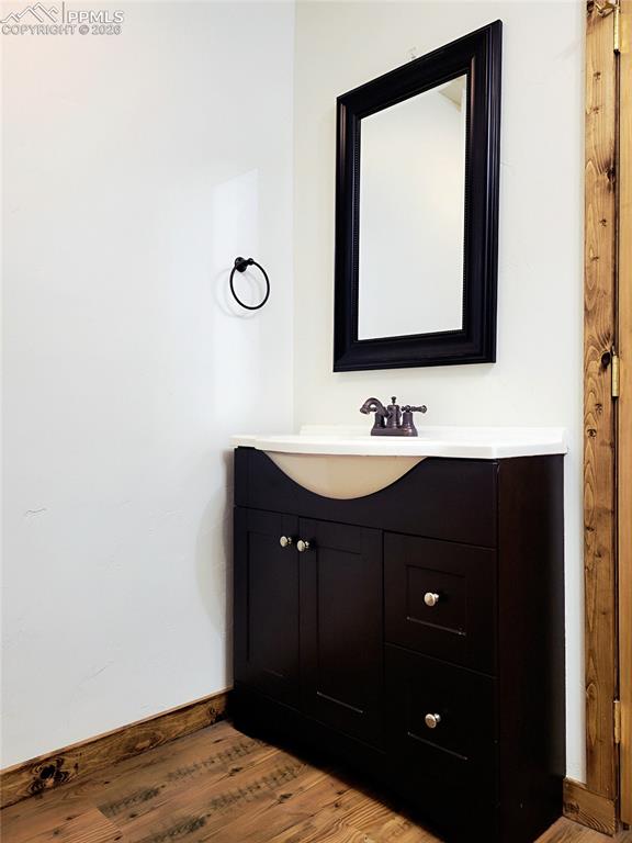 Image 18 of 42: Bathroom featuring a dark wood vanity with a white countertop and basin, a