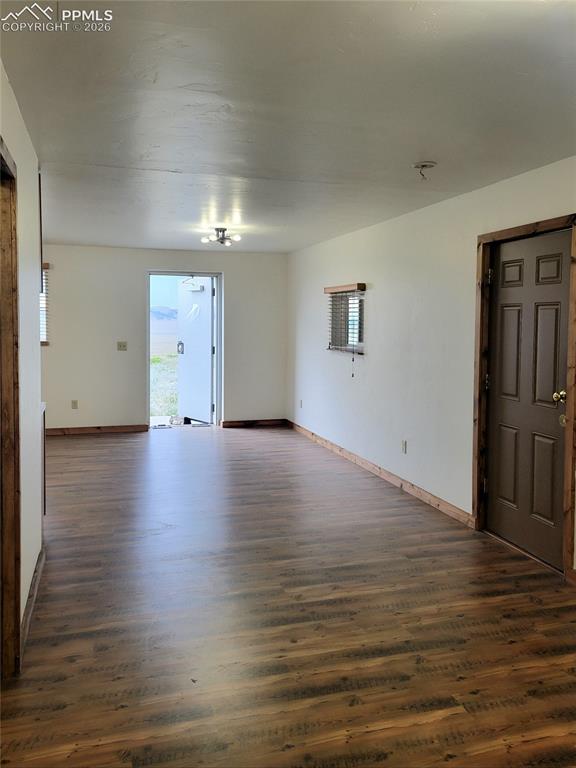 Image 20 of 42: This spacious room features wood-look flooring and a ceiling-mounted light