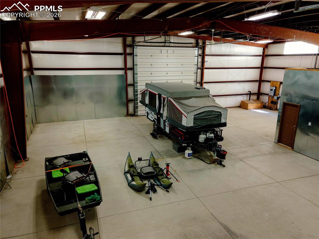 Image 22 of 43: Spacious interior featuring a concrete floor, high ceilings with exposed be