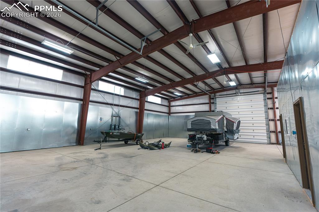 Image 25 of 43: Spacious interior with concrete flooring and exposed metal beam constructio