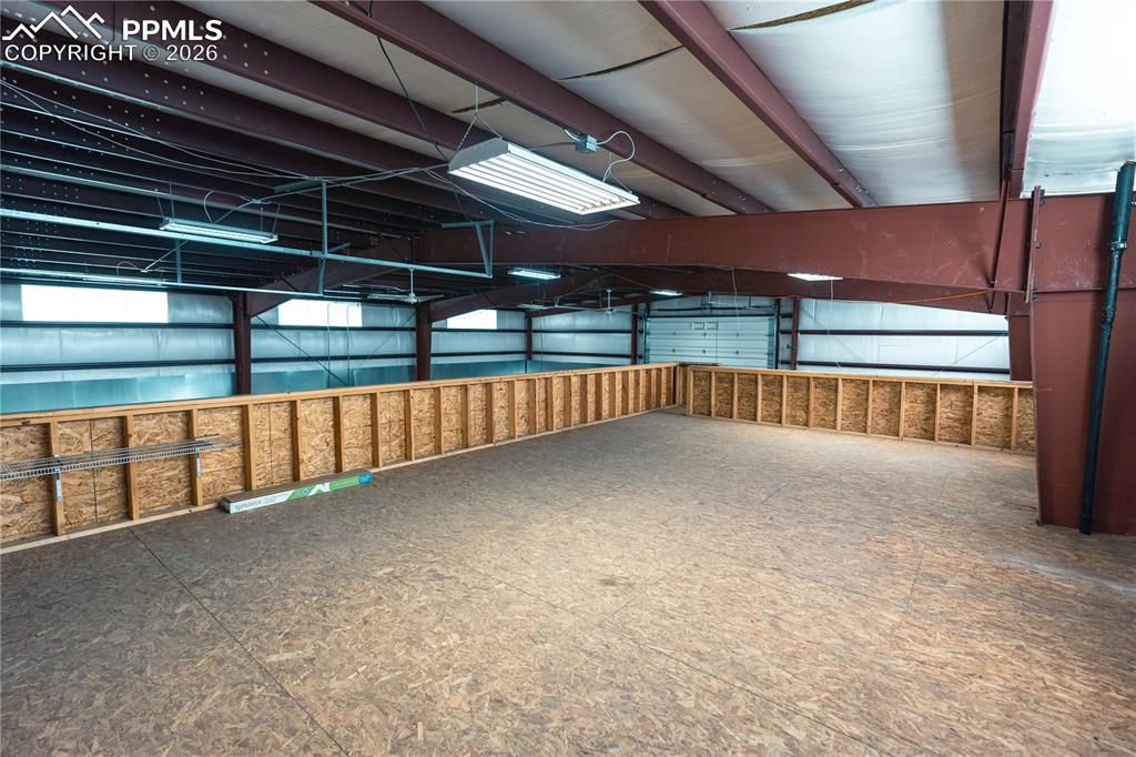 Image 29 of 43: The property features an expansive open space with exposed structural beams