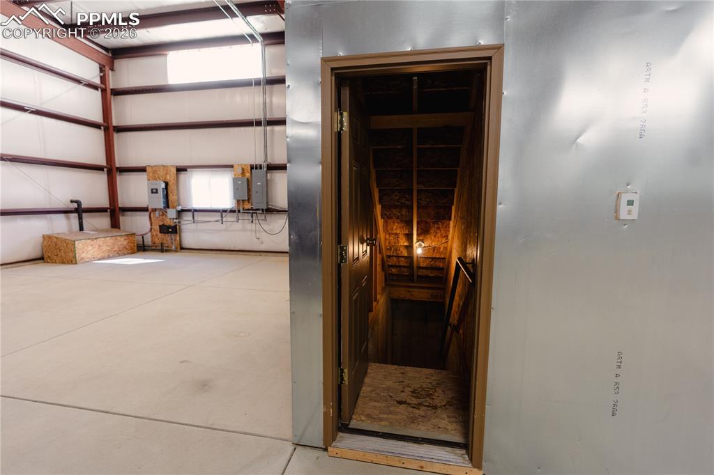 Image 33 of 43: The property features an expansive open space with a concrete floor, expose